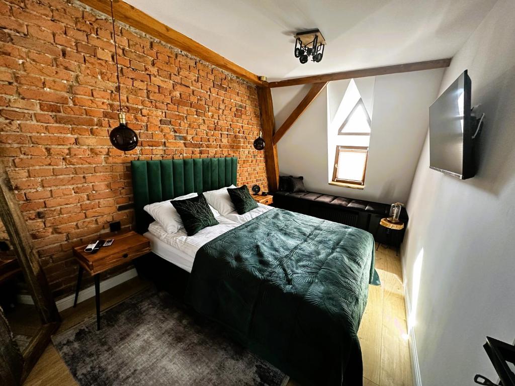 a bedroom with a bed and a brick wall at Apartament Miodowy - DARMOWY PARKING - KlMATYZACJA - WIFI in Toruń