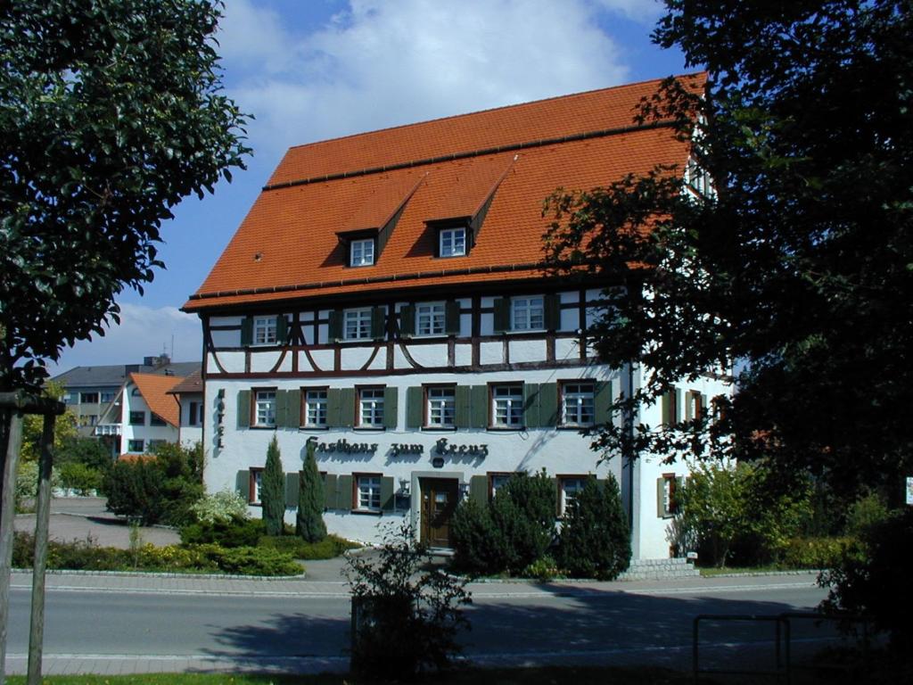 ein großes weißes Gebäude mit rotem Dach in der Unterkunft Gasthaus Hotel zum Kreuz in Stetten am Kalten Markt