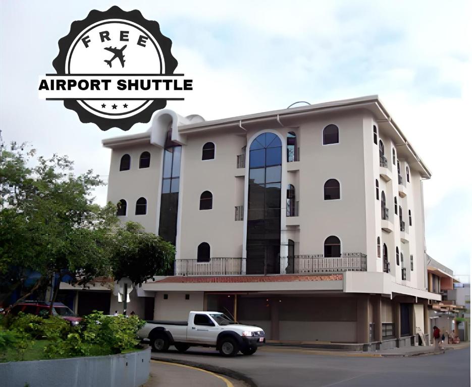 a building with a truck parked in front of it at Alajuela Backpackers Airport Hostel in Alajuela City