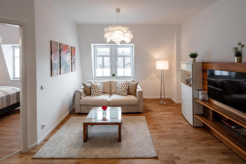 a living room with a couch and a coffee table at Goethe Palais Suite Zauberlehrling 4P l Lift l Parkplatz in Aue