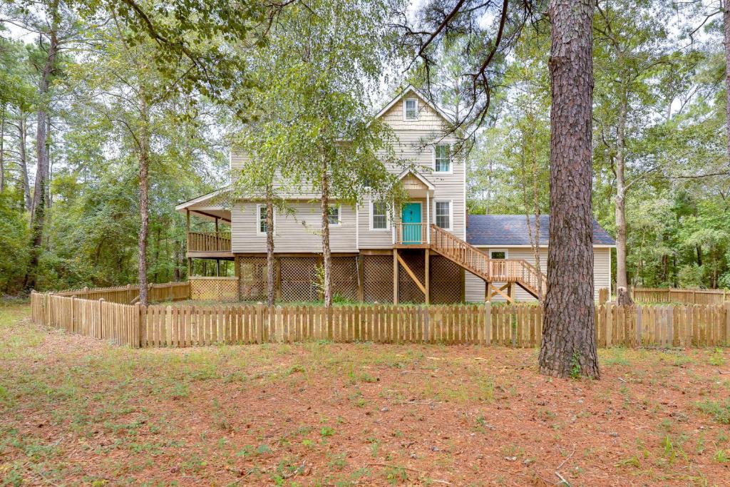 a house in the woods with a fence at Waterfront Burgaw Vacation Rental with Private Yard! in Burgaw