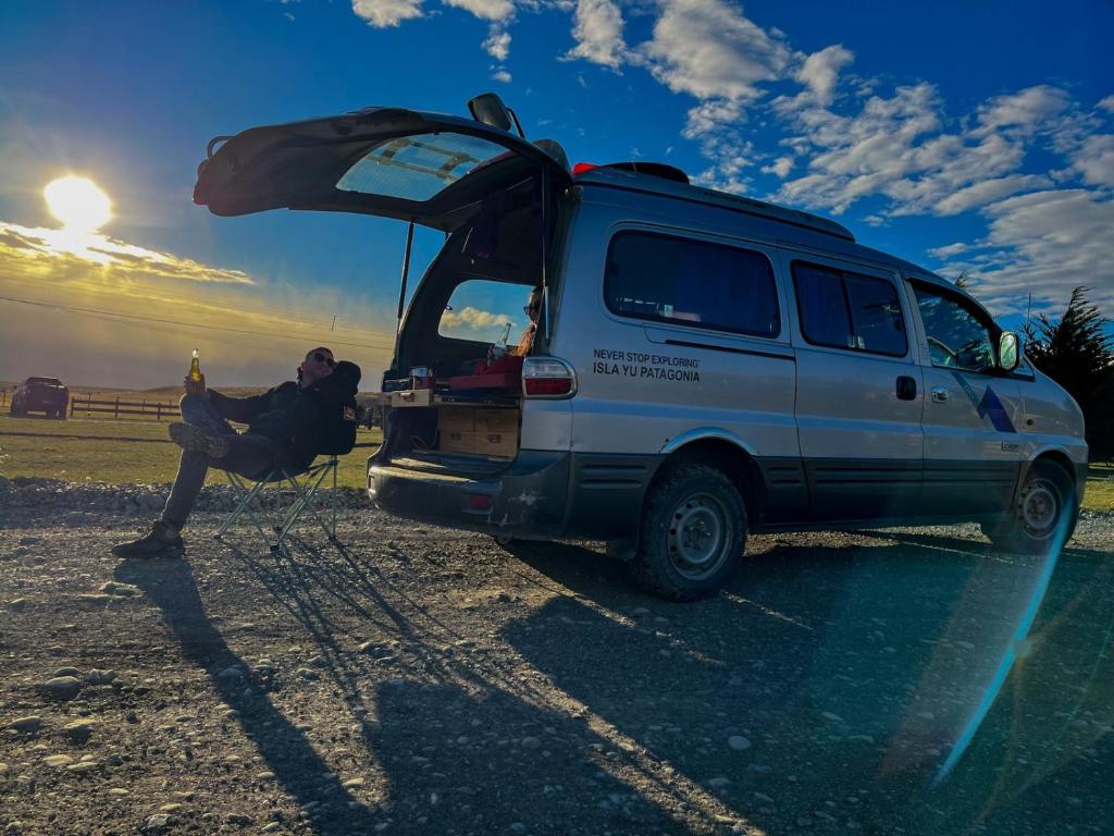 納塔列斯港的住宿－Isla Yu Patagonia，站在一辆面包车旁边,门开着的人