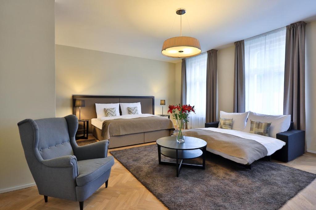 um quarto de hotel com duas camas e uma cadeira em James Hotel & Apartments em Praga