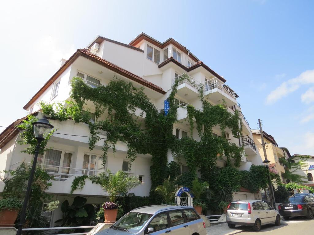 un edificio blanco con muchas plantas. en Family Hotel Sofi en Sozopol