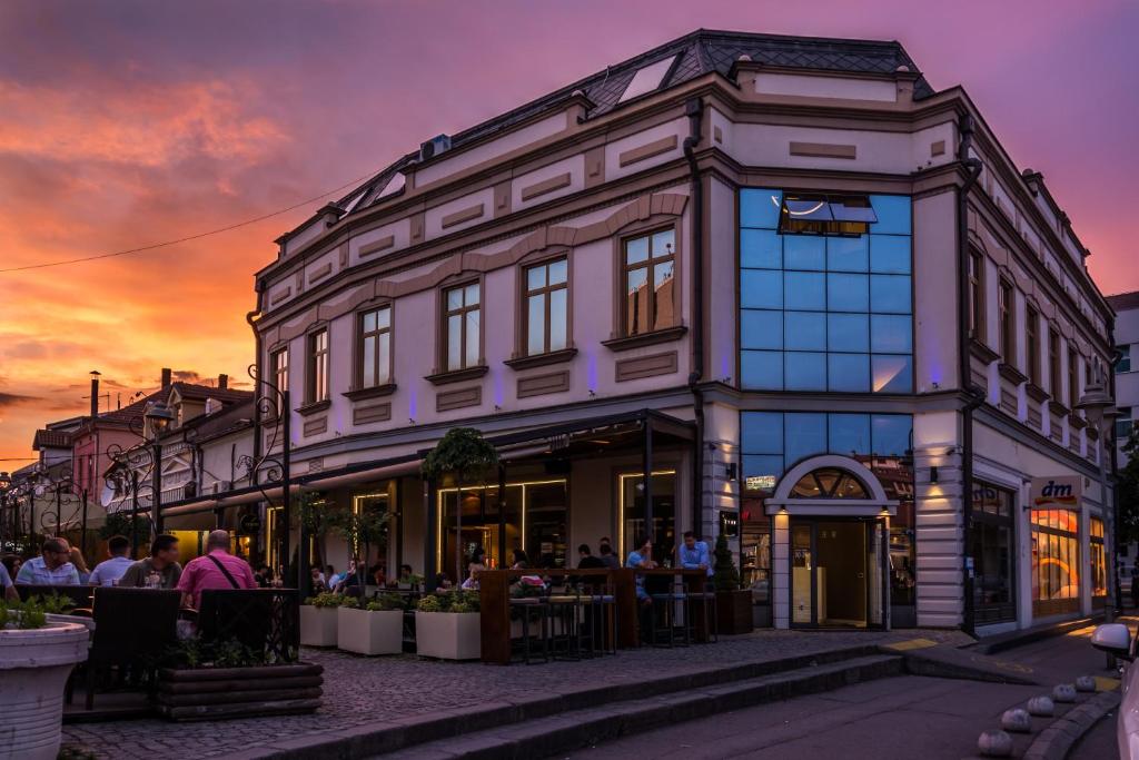 budynek z ludźmi siedzącymi poza nim w obiekcie Garni Hotel Eter w Niszu