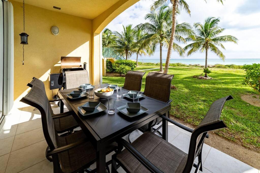 una mesa y sillas en un patio con vistas al océano en Paradise Retreat, A Tropical Oceanfront Villa en Freeport