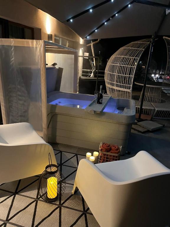 a large white tub in a room with two chairs at H49 Jacuzzi Penthouse-Adults only in Sovata
