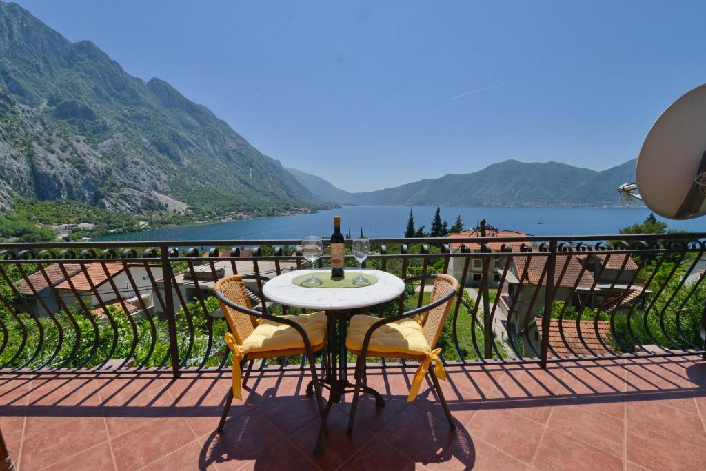 d'une table et de chaises sur un balcon avec vue sur la rivière. dans l'établissement J & P Apartments Orahovac, à Kotor