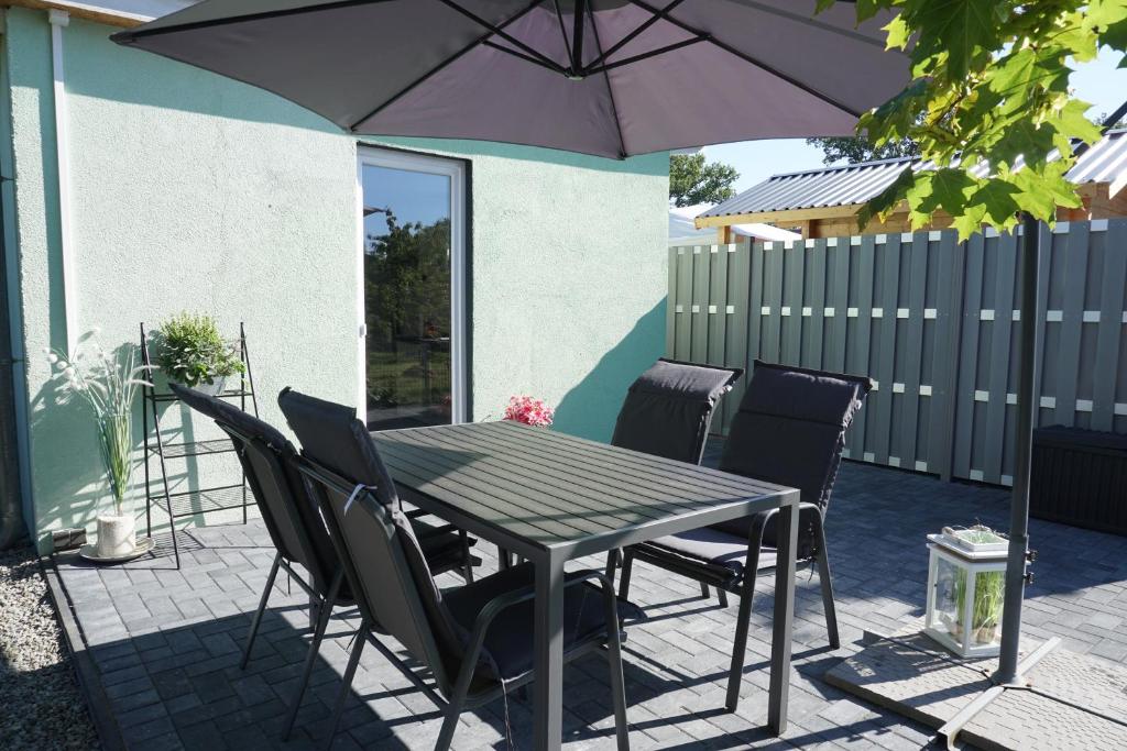 einen Tisch und Stühle mit Sonnenschirm auf einer Terrasse in der Unterkunft Ferienhaus Seekoje in Neustadt-Glewe