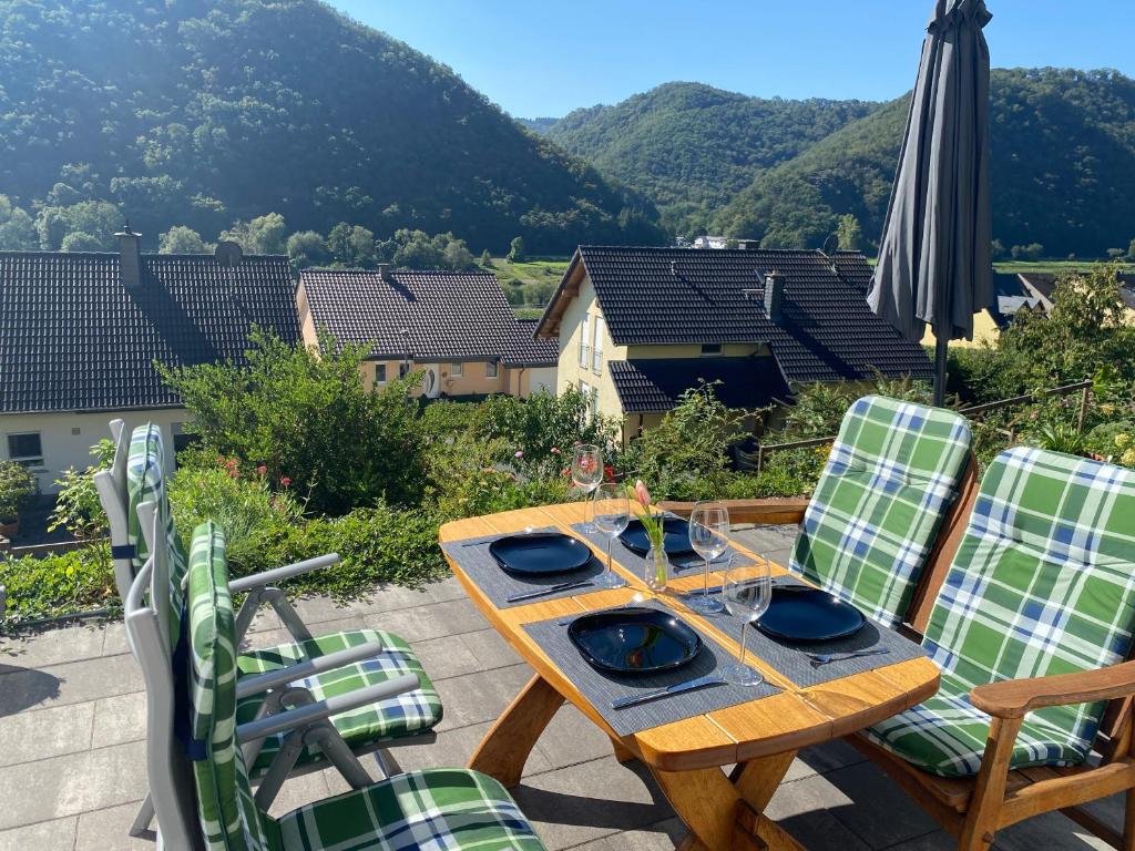 einen Holztisch und Stühle auf einer Terrasse mit Bergblick in der Unterkunft Ferienwohnung Sonnenterrasse, 1-4 Personen, 2 Schlafzimmer, große Terrasse in Müden