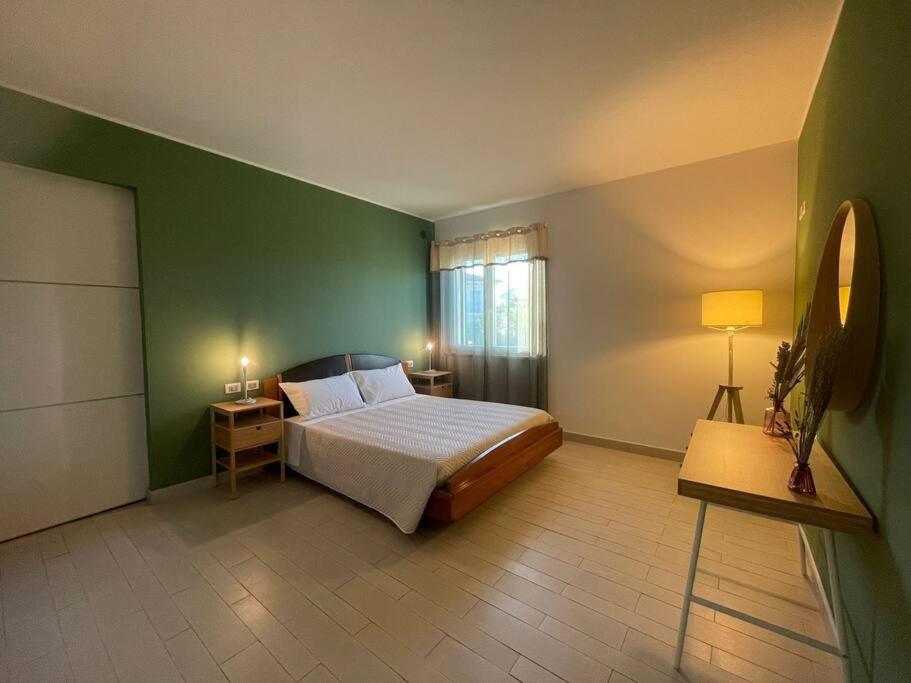 um quarto com uma cama e uma parede verde em Dimora Mirtilla - alloggio, max 4 posti letto. em Petacciato