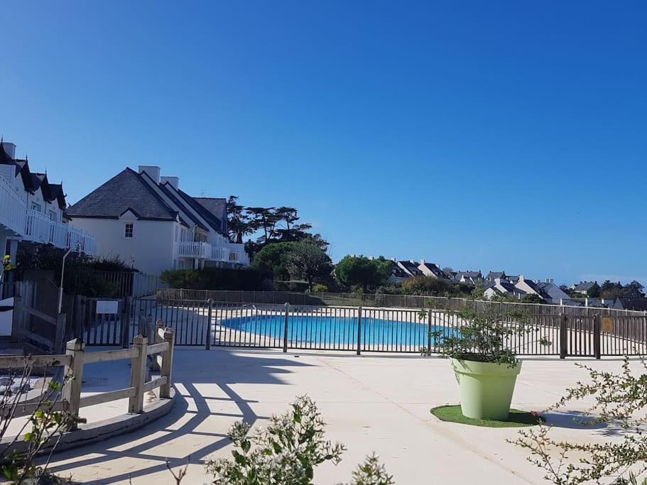 uma piscina com uma cerca ao lado de uma casa em Résidence cap océan, Port du Crouesty em Arzon