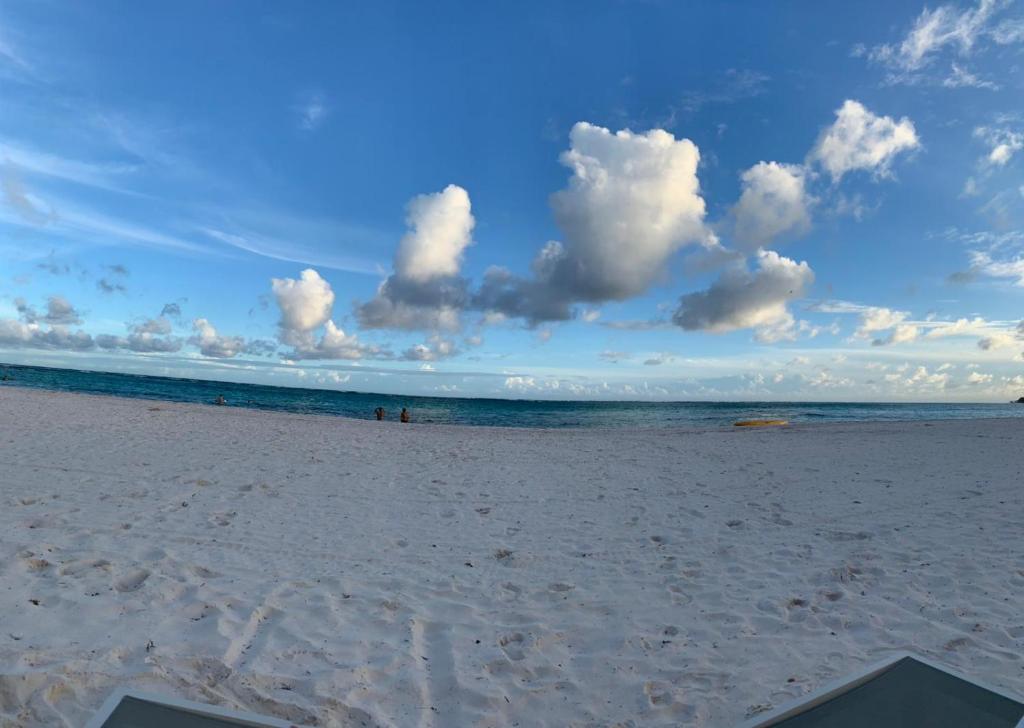 una playa con un cielo nublado y el océano en Pool Breeze 202 en Punta Cana