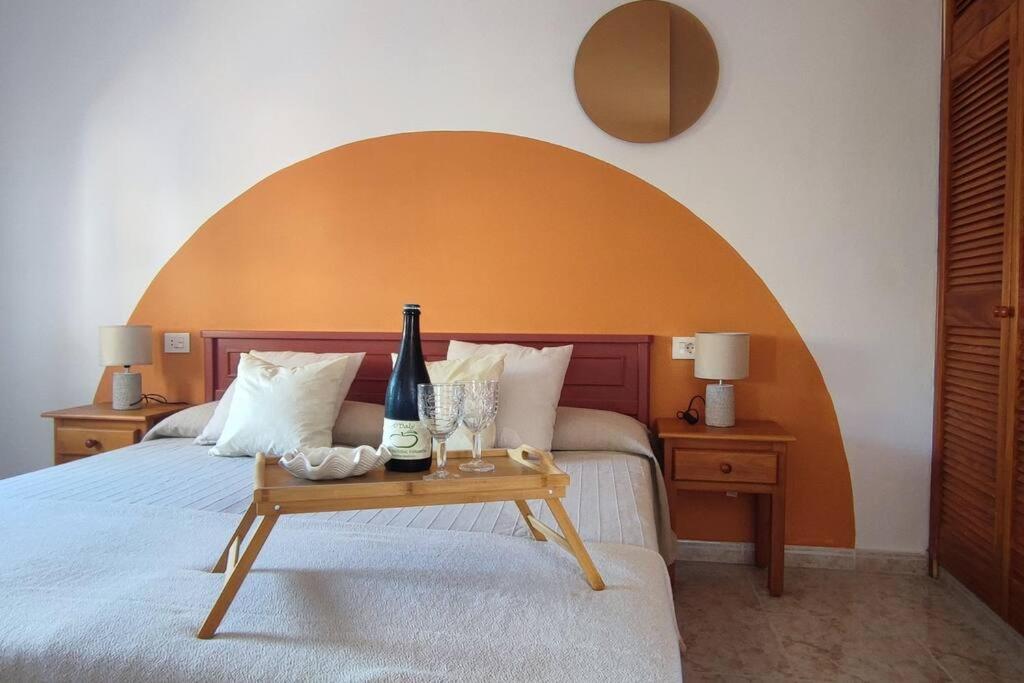 uma cama com duas garrafas de vinho numa mesa em Finca de Sal em Mazo