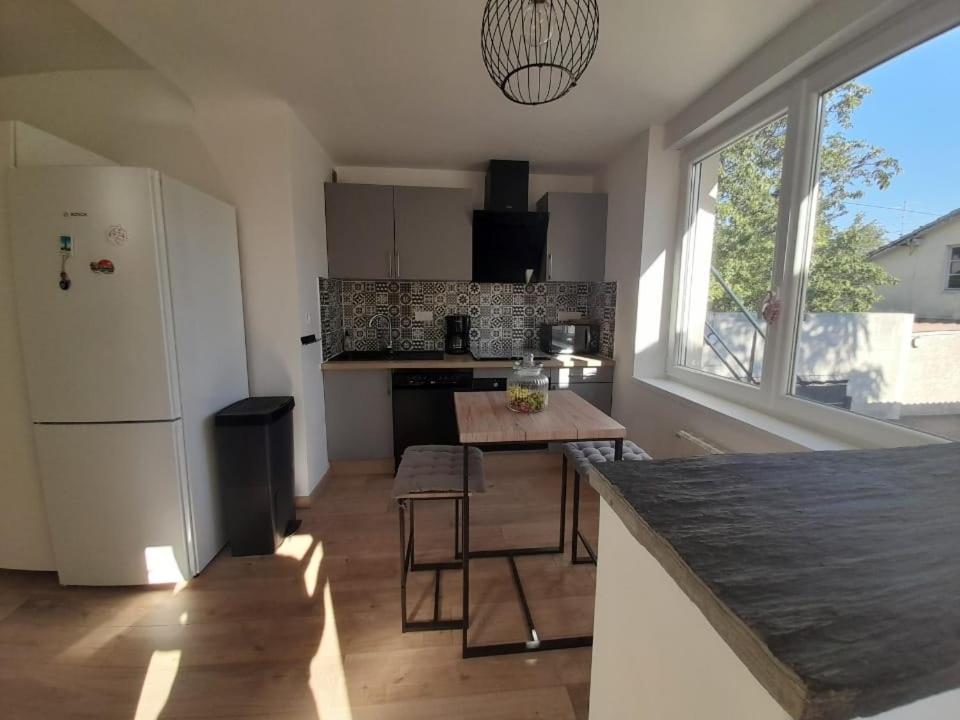 uma cozinha com um frigorífico branco e uma mesa em Gîte le Séquoia em Sélestat