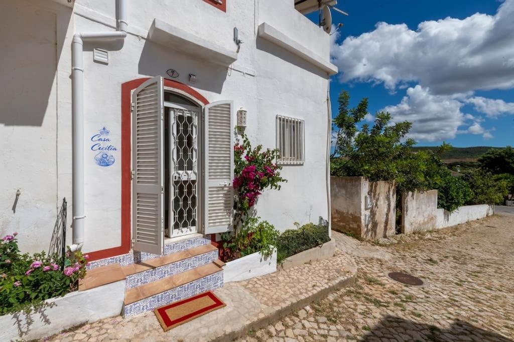 une maison blanche avec une porte rouge et des escaliers dans l'établissement Casa Cecilia Apartment Algarve, à Alte