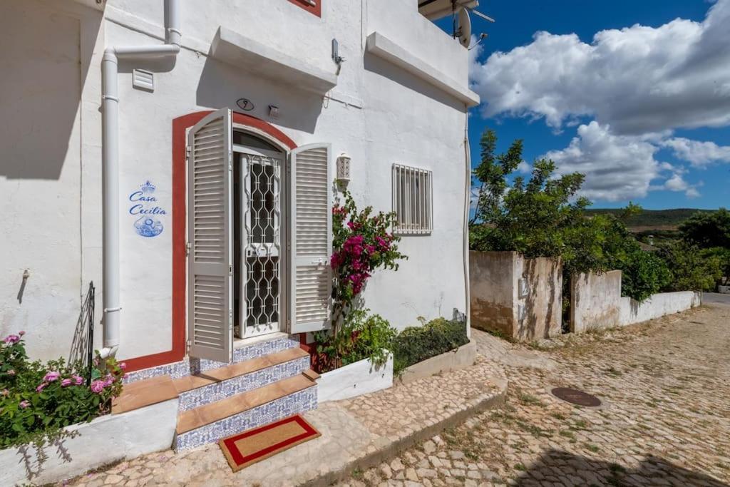 ein weißes Haus mit einer roten Tür und einer Treppe in der Unterkunft Casa Cecilia Apartment Algarve in Alte