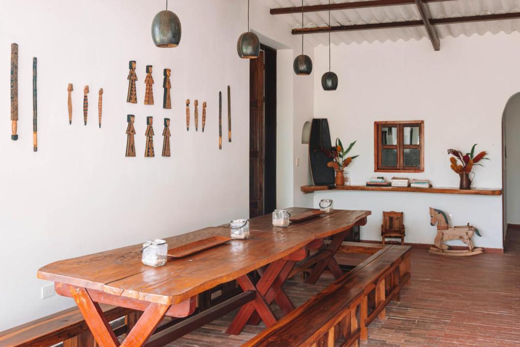 uma sala de jantar com uma mesa de madeira e artefactos na parede em MONTAIN ECO LODGE MUNDO ALTO em Minca