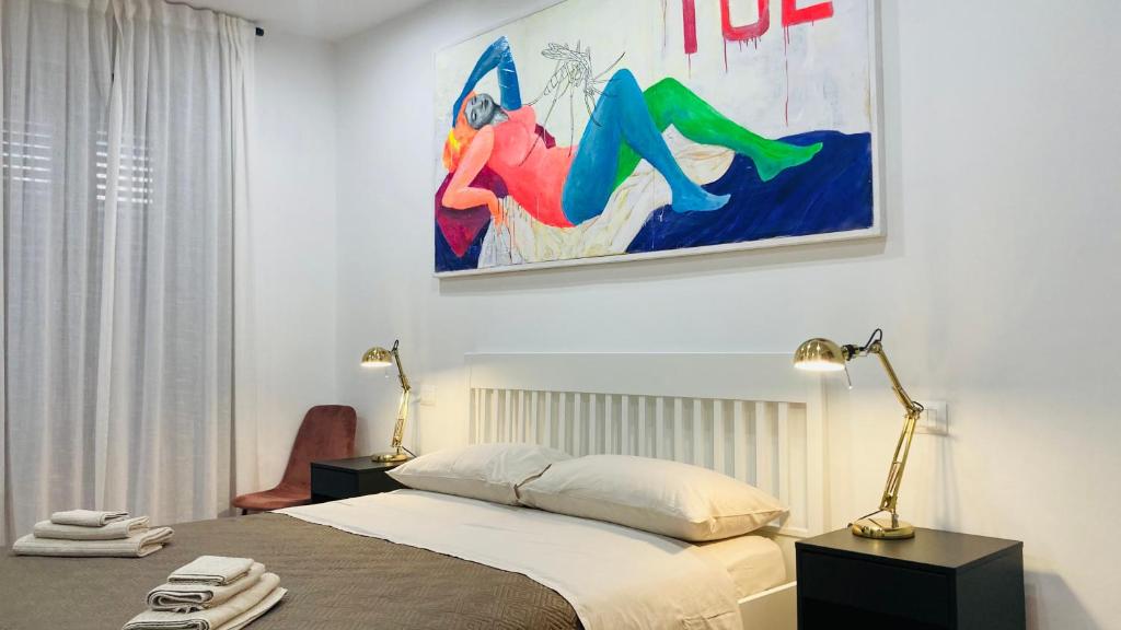 a bedroom with a bed and a painting on the wall at Palestro 8_Art Holiday House in Caramanico Terme