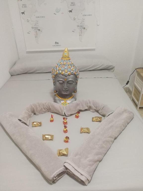 a statue of a head on a bed with gold jewelry at Habitacion en Castilleja de la Cuesta in Castilleja de la Cuesta