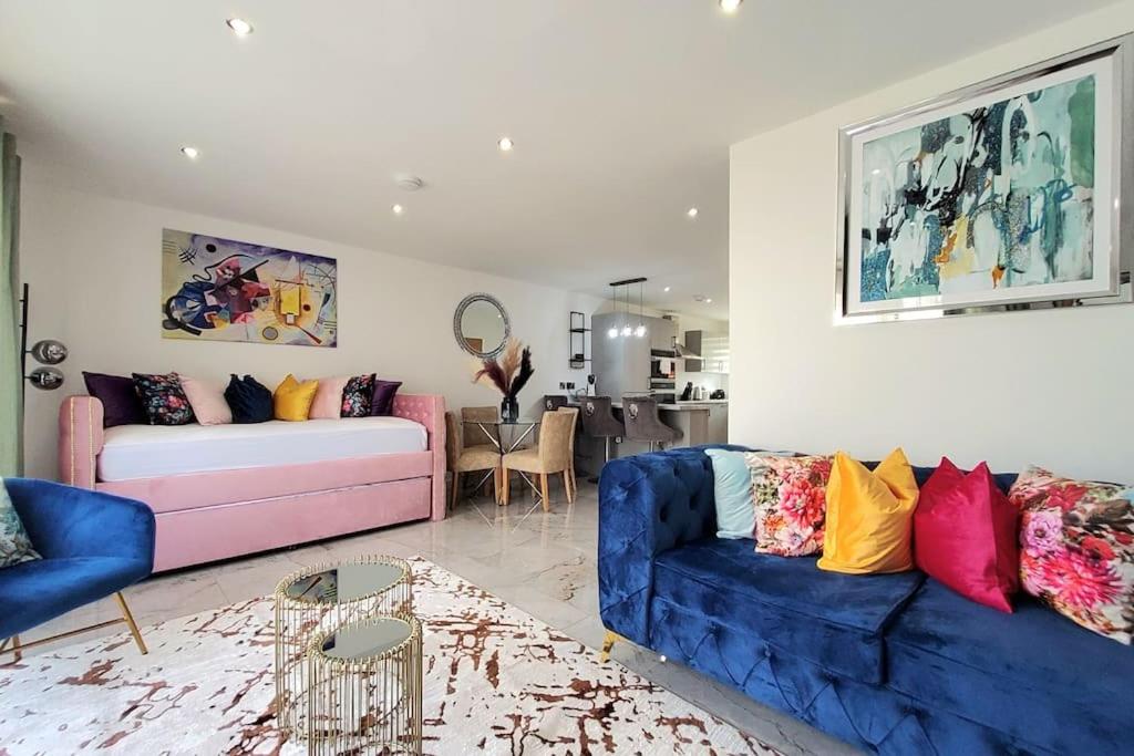 Three Bedrooms House By Sensational Stay Short Lets & Serviced Accommodation With Free Parking & Wi-fi في Ballingry: غرفة معيشة مع أريكة زرقاء وأريكة وردية