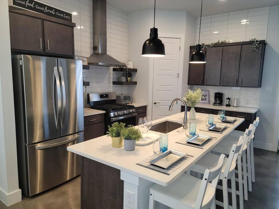 a kitchen with a large island in a kitchen with a refrigerator at The Alamo Riverwalk Pearl Modern 4 Bedroom Home in San Antonio