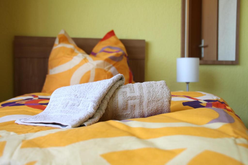 Una cama con mantas y almohadas coloridas. en Pension an der Werft, en Rostock