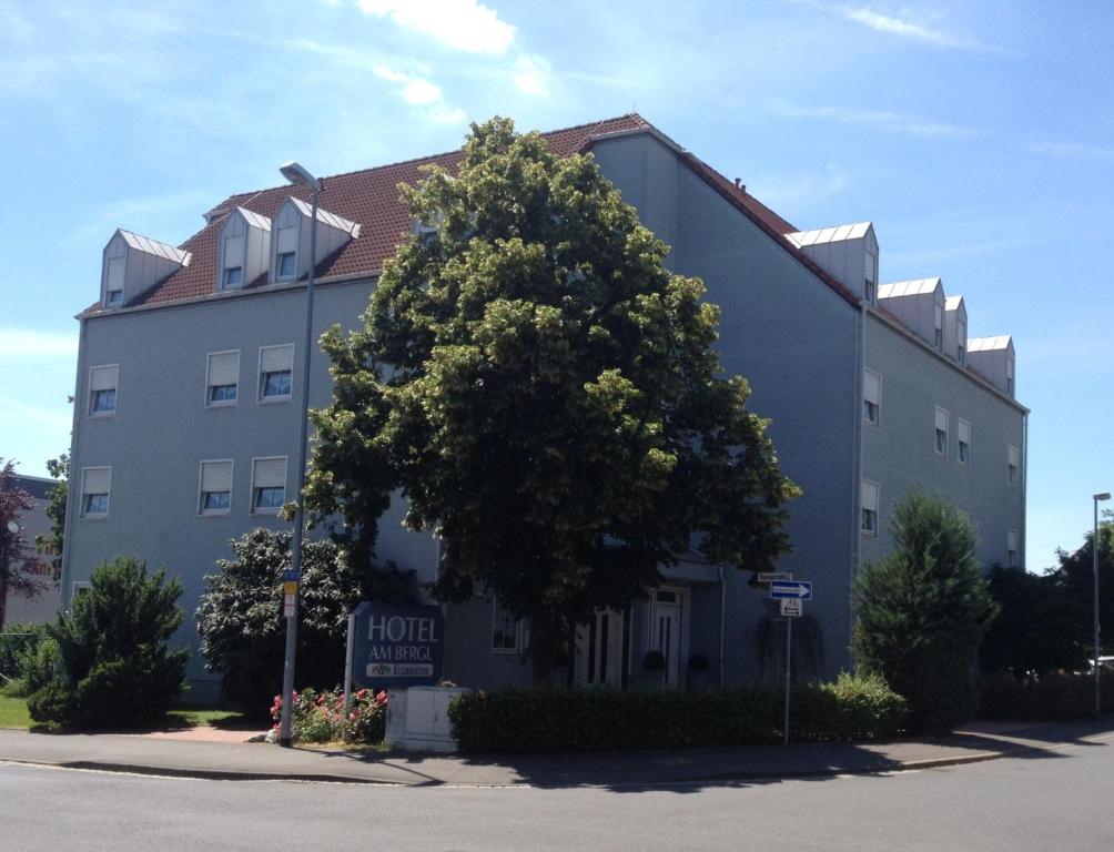 un grand arbre devant un bâtiment dans l'établissement Hotel am Bergl, à Schweinfurt