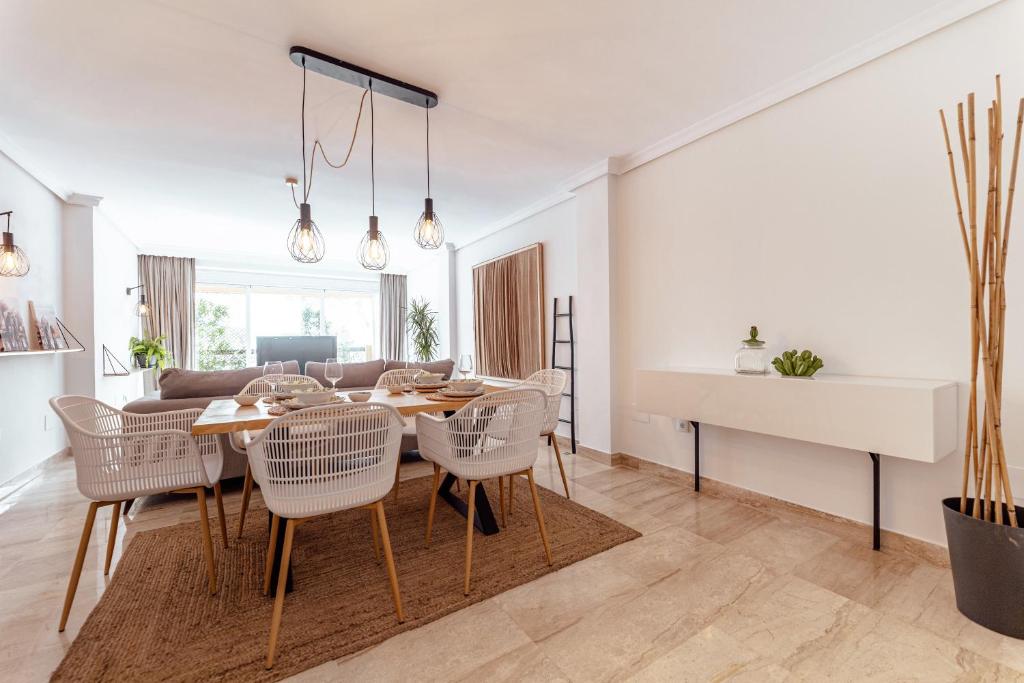 a dining room and living room with a table and chairs at Elviria beach Award-Winning Stay in Marbella