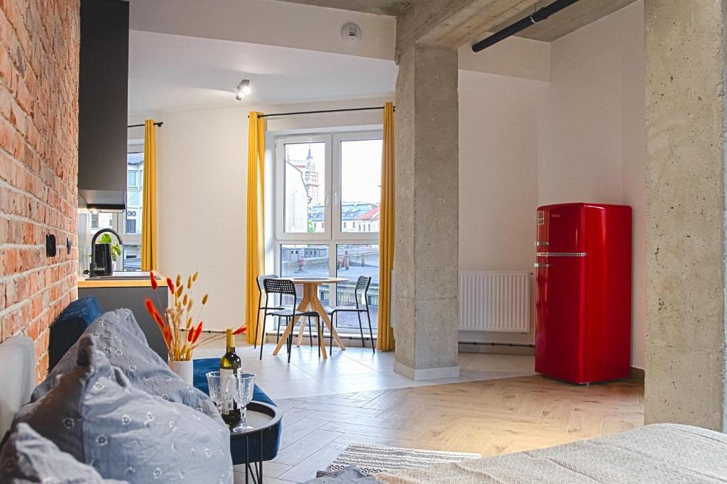 a living room with a red refrigerator and a table at Loft deLUX #nestapartamenty in Bielsko-Biala