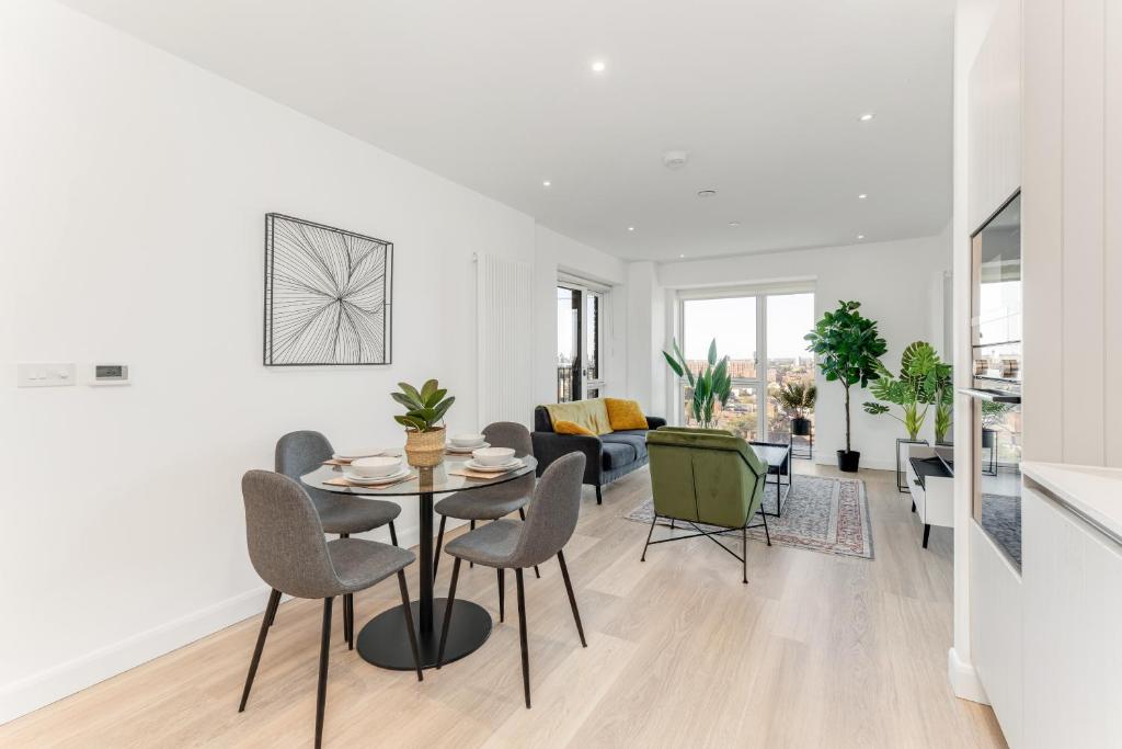 een woonkamer met een tafel en stoelen bij Docklands Two Bed Apartment in Londen