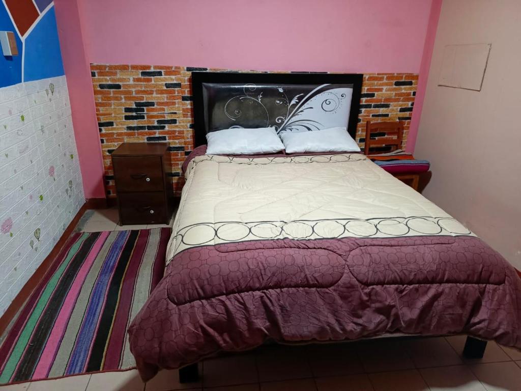 Backpacker hostal oruro في أورورو: غرفة نوم بسرير كبير مع لوحة للرأس