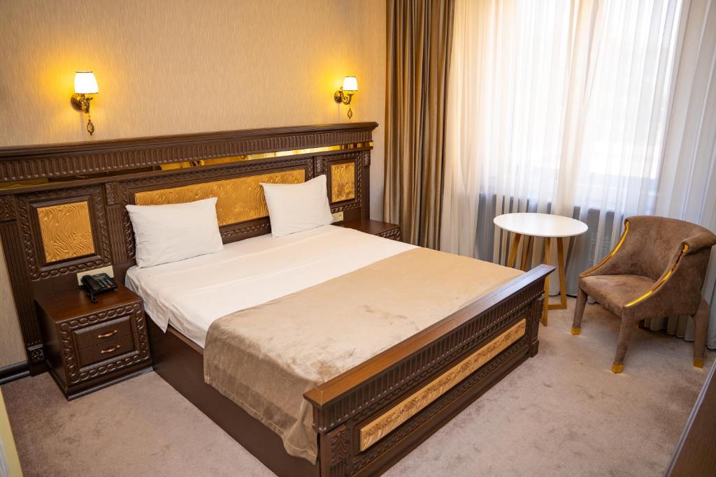 ein Hotelzimmer mit einem Bett und einem Stuhl in der Unterkunft The Krone in Baku