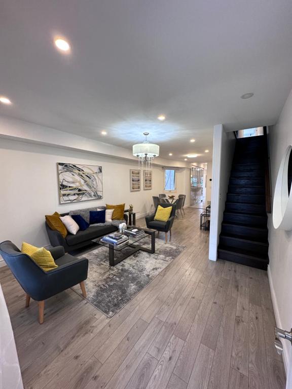 uma sala de estar com sofás e cadeiras e uma escadaria em Toronto GREAT Located em Toronto