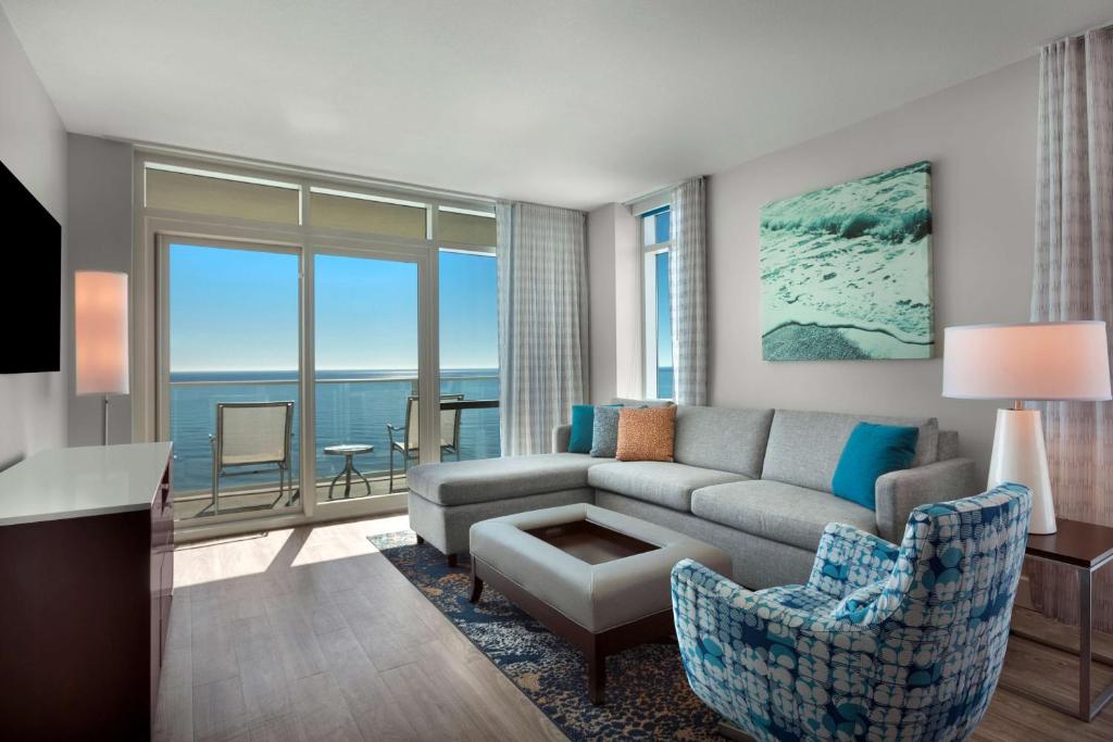 a living room with a couch and a view of the ocean at Hilton Grand Vacations Club Ocean 22 Myrtle Beach in Myrtle Beach
