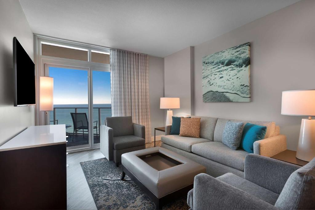 a living room with a couch and a room with a view at Hilton Grand Vacations Club Ocean 22 Myrtle Beach in Myrtle Beach
