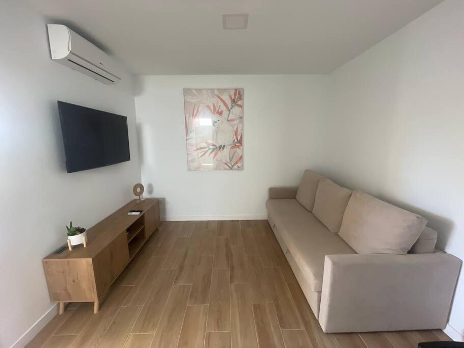 uma sala de estar com um sofá e uma televisão em Apartamento D&L em Costa Del Silencio