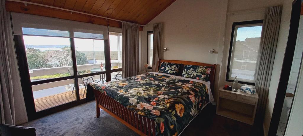 um quarto com uma cama e uma grande janela em Auckland Beachview Homestay with free Netflix, Parking em Auckland