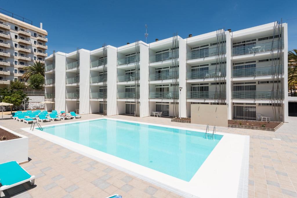 普拉亞戴爾雷安格萊斯的住宿－EO拉斯羅薩斯公寓，大楼前的游泳池