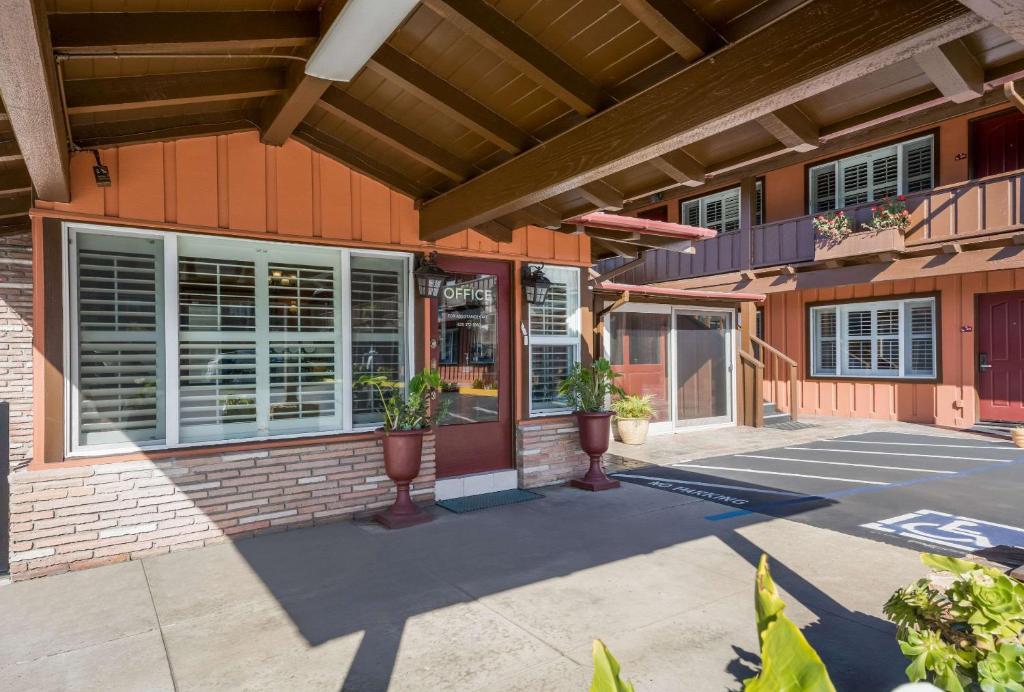 a front entrance to a building with windows and plants at Clarion Collection Wilkie's Inn Pacific Grove - Monterey in Pacific Grove