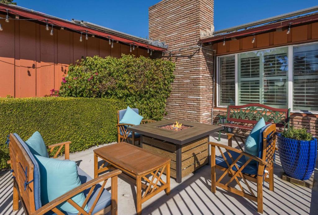 a patio with a table and chairs and a fire pit at Clarion Collection Wilkie's Inn Pacific Grove - Monterey in Pacific Grove