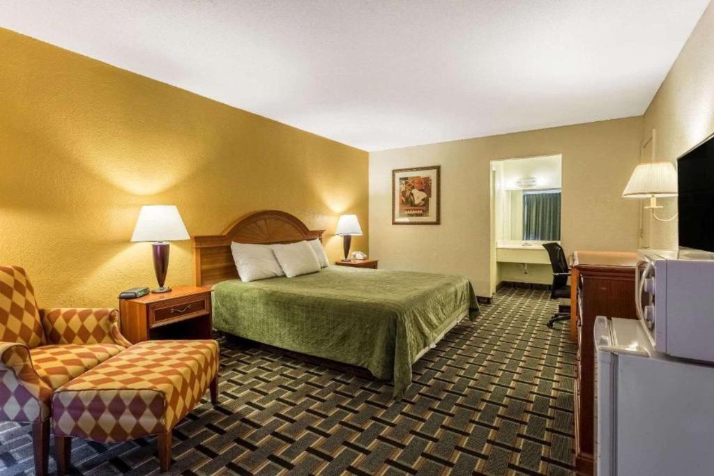 a hotel room with a bed and a chair at Rodeway Inn Denmark-Jackson in Denmark