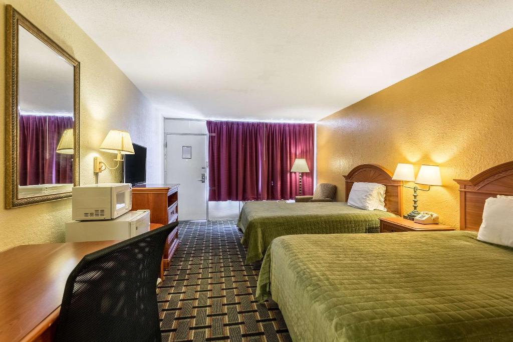 a hotel room with two beds and a television at Rodeway Inn Denmark-Jackson in Denmark