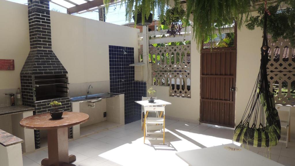 a kitchen with a stove and a table and a stool at Casa Aconchegante in Maresias