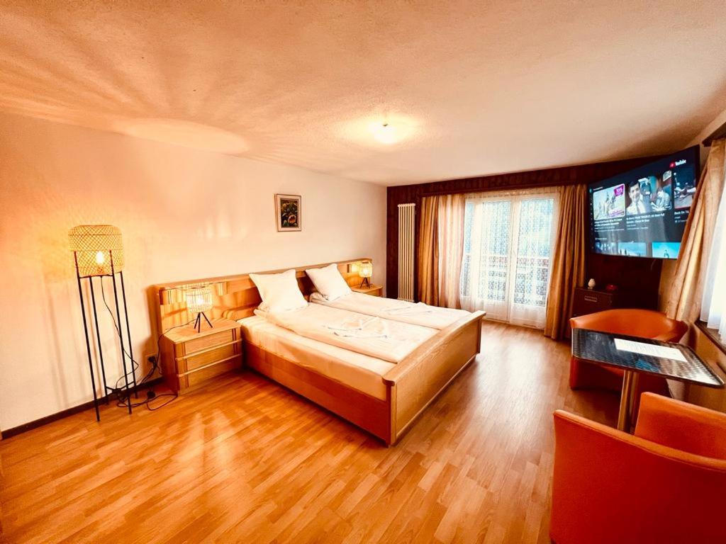 Schlafzimmer mit einem Bett und einem Flachbild-TV in der Unterkunft Apartment with balcony and Panoramic Views of Alps in Klosters Serneus