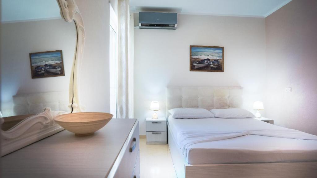a bedroom with a bed and a wooden bowl on a table at Sea view apartement in Durrës