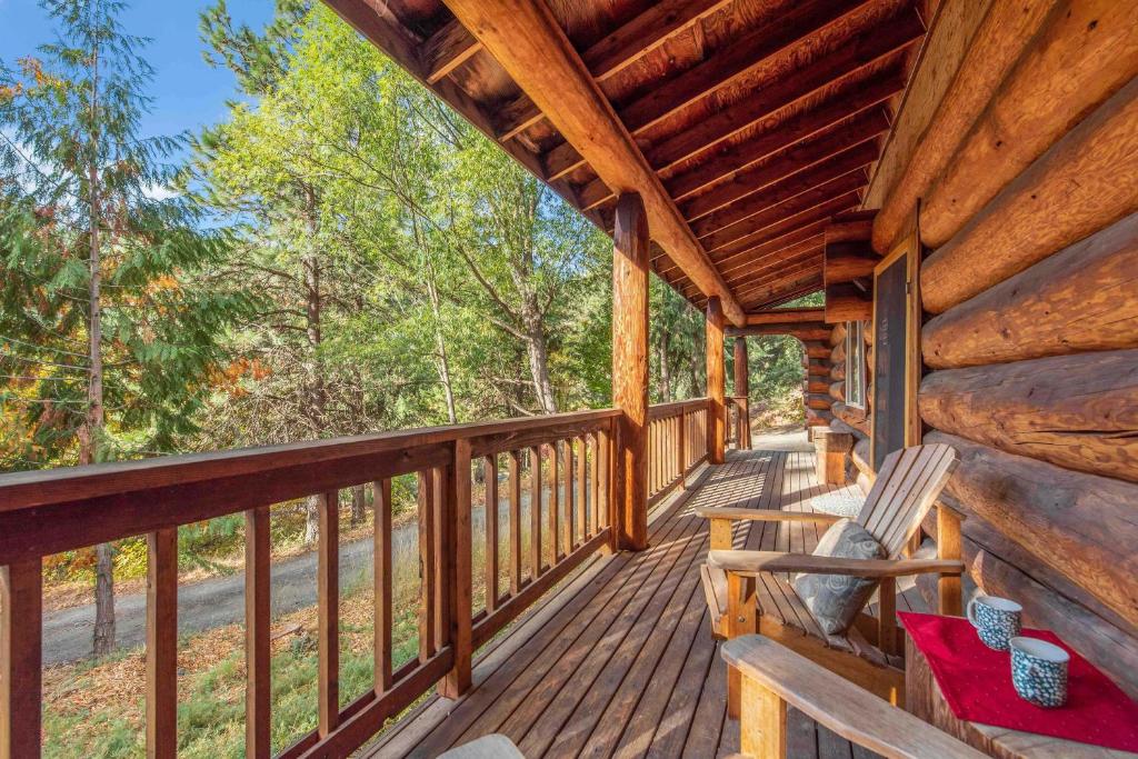 Bear Ridge Cabin في ليفنوورث: شرفة كابينة عليها كرسي هزاز