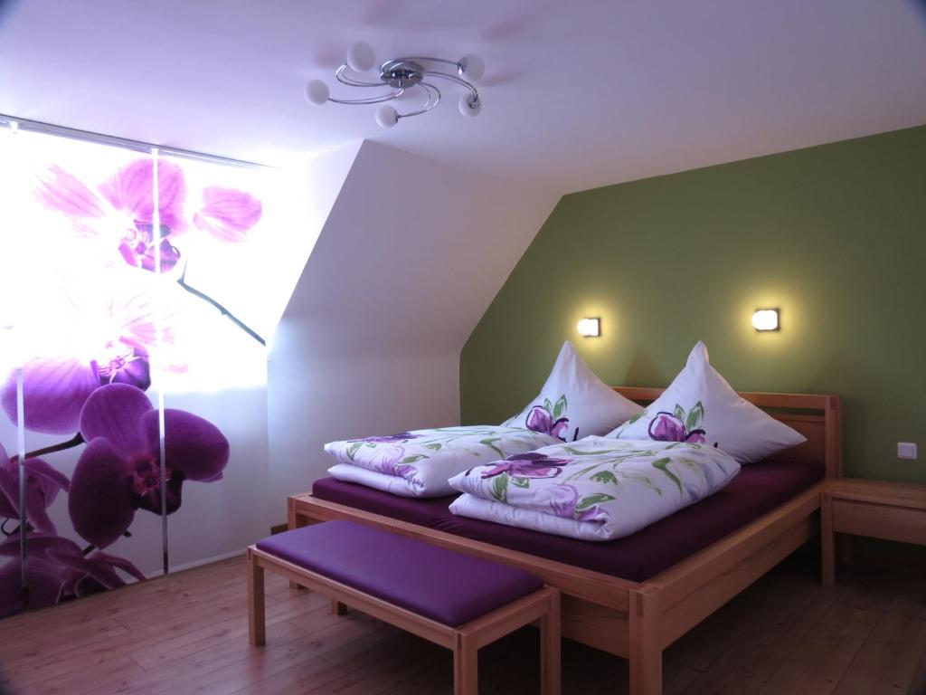 Schlafzimmer mit einem Bett mit lila und weißen Kissen in der Unterkunft Ferienoase ENGEL in Überlingen