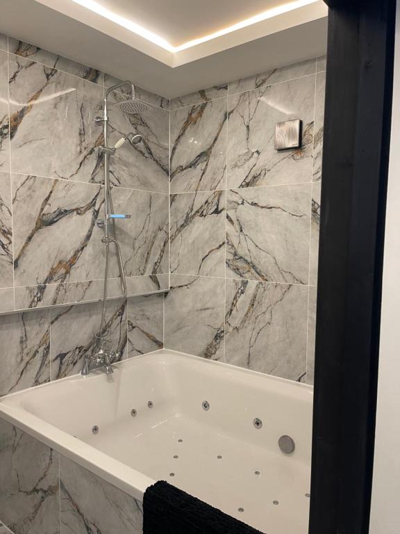 a white bath tub in a bathroom with marble walls at RESIDENCY LUXURY SEAFRONT HOTEL in Blackpool