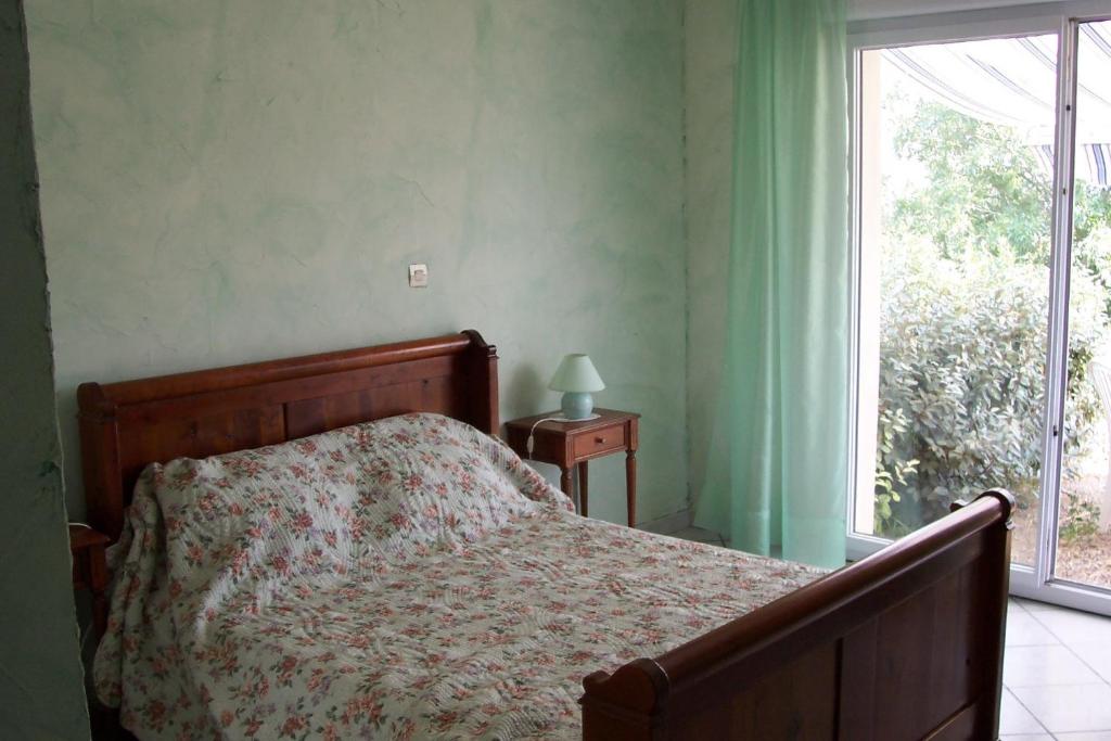 1 dormitorio con cama y ventana en Le Fenouillet Chambres D'hotes proche des Grands Buffets en Narbona